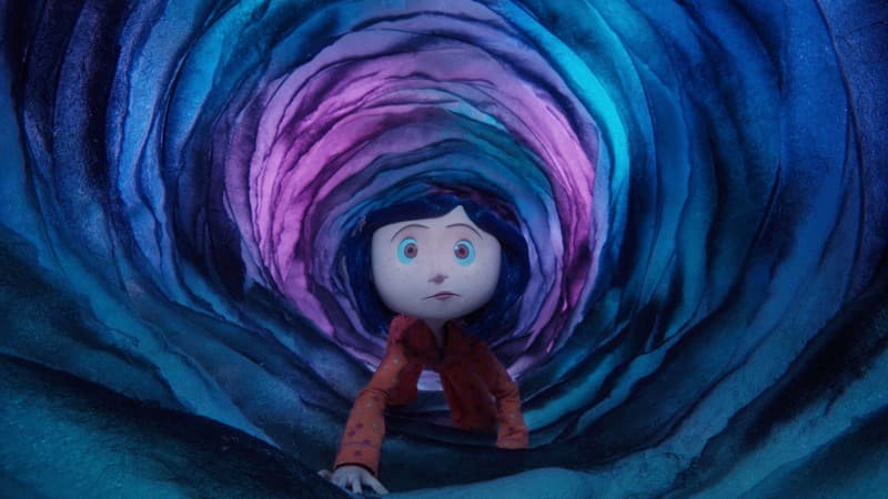 Coraline (fromt the animated film “Coraline”) crawls through a narrow tunnel, appearing nervous.